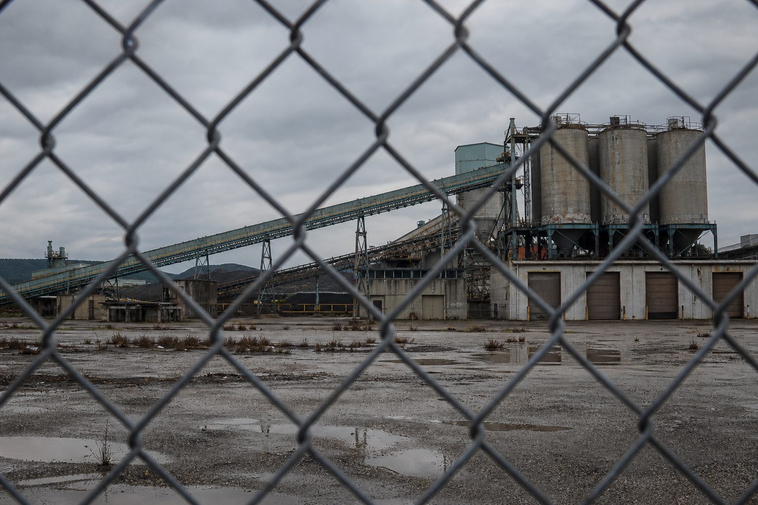 Idle Chinese mineral processing facility behind a chain-link fence.